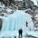 Standing in front of a waterfall that has completely frozen over